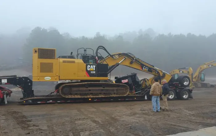 Excavator-mounted ProGrind mulching head clearing dense vegetation efficiently.